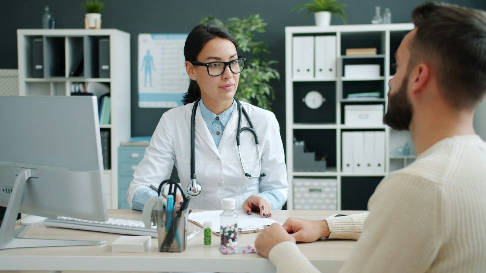 A doctor at her desk talking with a patient